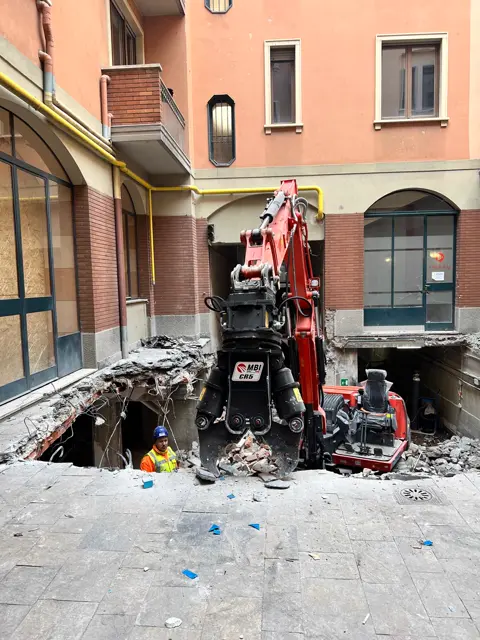 Mini escavatore tra le macerie di una demolizione in cortile