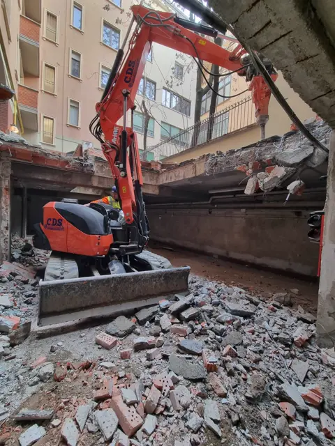 Escavatore durante uno scavo in sezione in cortile