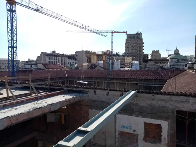 Cantiere in quota con gru sullo skyline di Milano