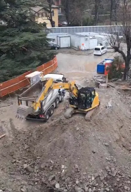 Escavatore CAT carica il camion durante uno scavo di sbancamento
