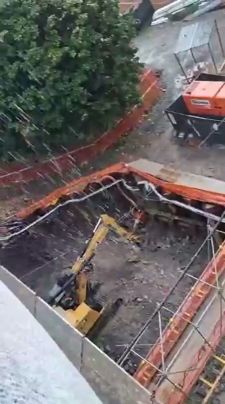 Scavo visto dall'alto con escavatore al lavoro
