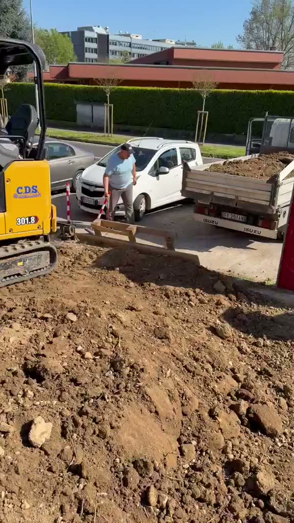 Mini escavatore e camion durante il movimento terra
